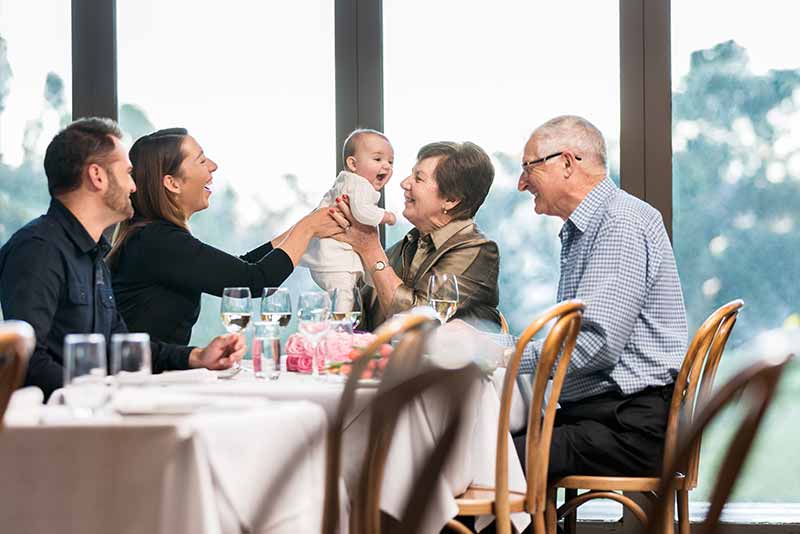 Parents and grandparents with kid having lunch